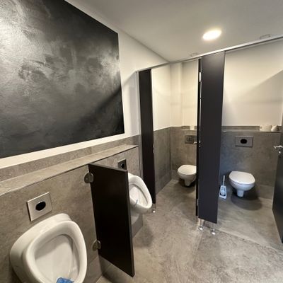 Sanitärbereich der Gemeindehalle Anschau mit großformatigen Wand- und Bodenfliesen